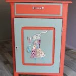 Petit meuble bas fermé, après rénovation, avec illustration peinte à la main sur le thème Alice au pays des merveilles
