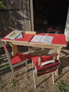 Décors de classe avec un pupitre et des chaises rénovés, cartable et un jouet ancien