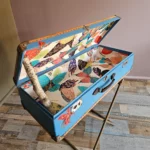 Malle aux papillons ouverte, avec peinture originale de papillon de la face avant visible et le tapissage intérieur